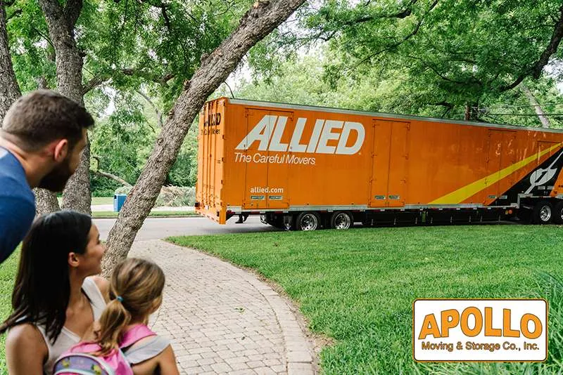 Father and daughter watching the Allied moving truck arrive at their home