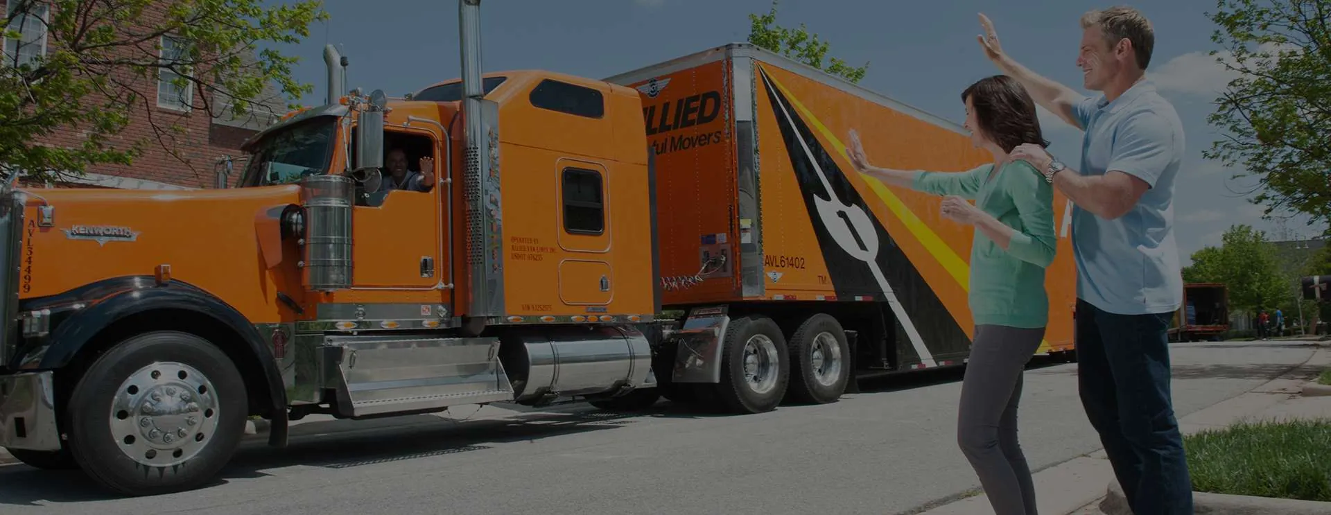 Allied driver shaking hands with a customer beside a moving truck